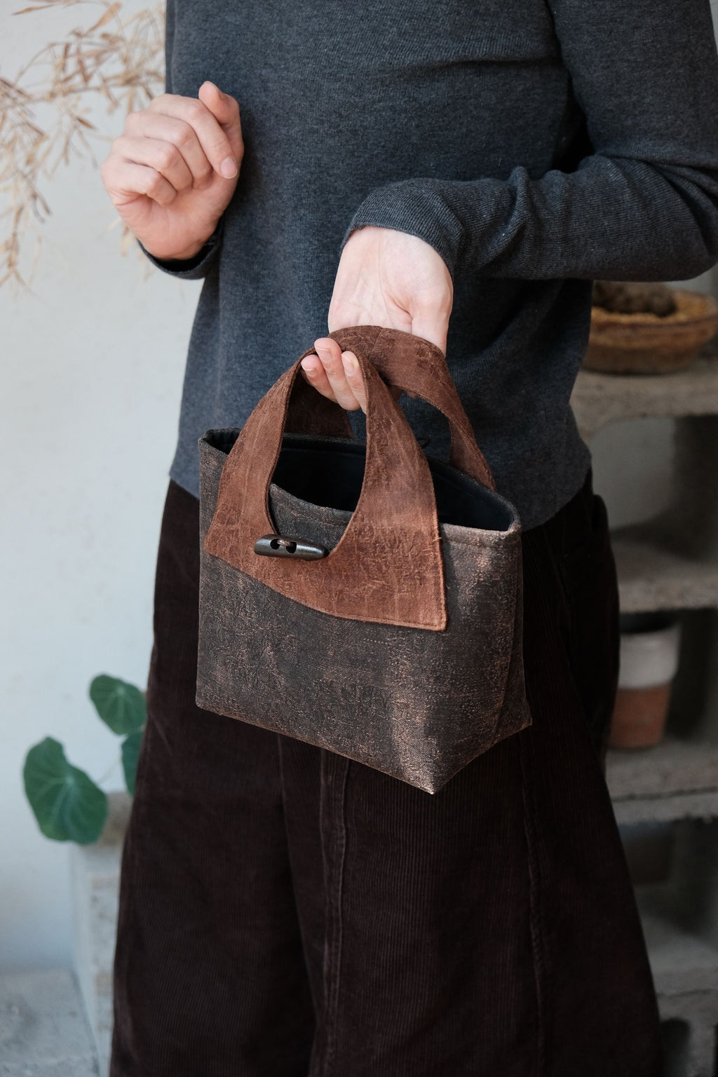 Artisan details of handmade Xiangyunsha silk handbag