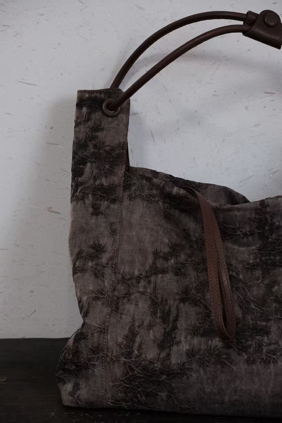 Detailed view of Xiangyunsha silk tote bag with genuine leather structure