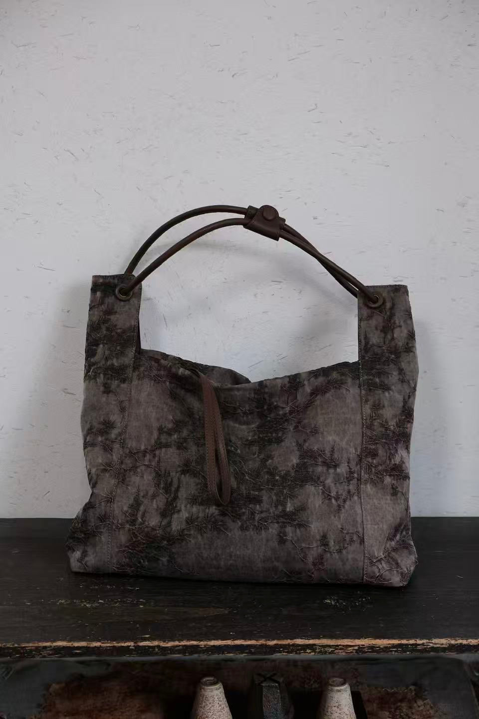 Front view of handmade Xiangyunsha silk leather handbag with elegant design