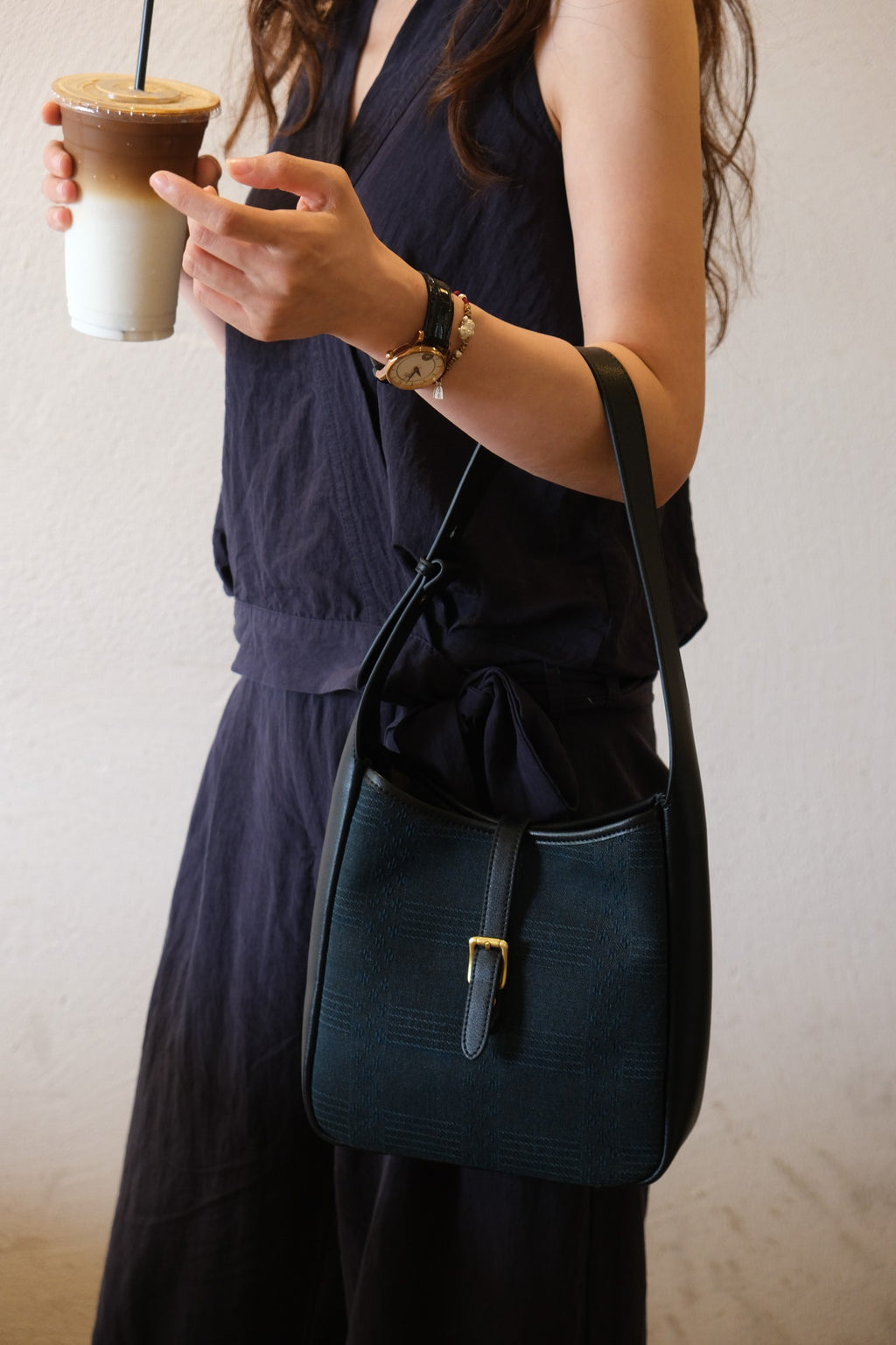 Lifestyle still‑life shot on wood surface, quiet luxury oriental handbag